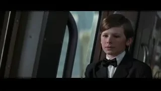young boy in tuxedo by window — Batman