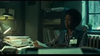 elderly woman at desk in dim office — Joker