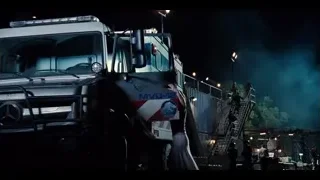 People working on large white truck at night — Jurassic World