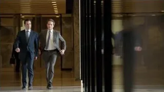two men in suits walking in office lobby — Suits