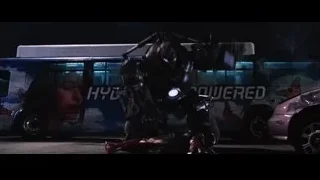 robot standing over person near bus — Iron Man