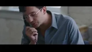 man sitting at desk looking at phone — The Big Short