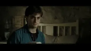 Daniel Radcliffe holding book in dimly lit room — Harry Potter and the Deathly Hallows 2