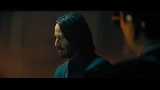 man in suit standing in dimly lit room — John Wick: Chapter 4
