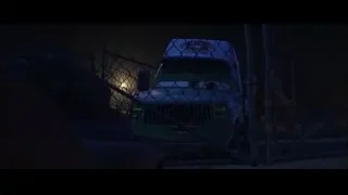 green truck parked behind chain-link fence — Cars 3