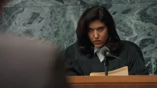 woman in robe speaking at courtroom podium — Suits