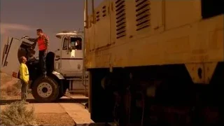 two men working on large truck on road — Breaking Bad