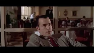 man in suit sitting in restaurant — American Psycho