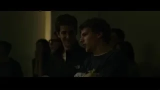 Two young men conversing in dimly lit room — The Social Network