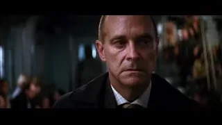 Bald man in crowded dimly lit room — Batman: The Dark Knight