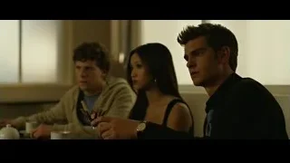three young people sitting at dimly lit table — The Social Network