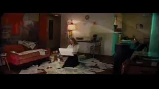 Woman reading paper on messy living room floor — La La Land