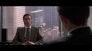 Man in suit conversing at office desk — American Psycho