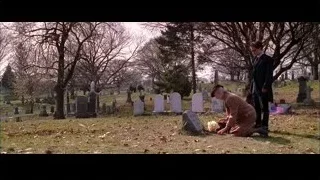 man kneeling by grave in cemetery with flag — Spider Man 2