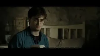 Harry Potter holding books in dimly lit room — Harry Potter and the Deathly Hallows 2
