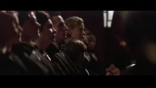 Group of people in suits in dimly lit room — Batman