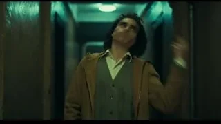Man standing in dimly lit dilapidated hallway — Joker