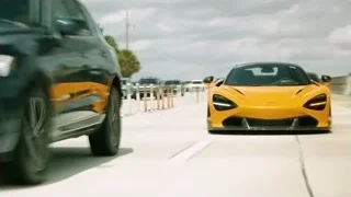 orange McLaren driving on highway with city skyline — Sports Cars