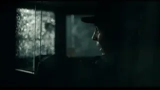 person in hat looking out rainy car window — Peaky Blinders
