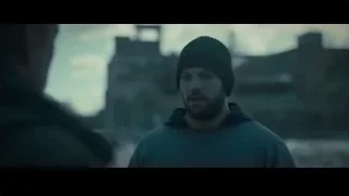 Man in beanie and jacket in front of cityscape — Creed 2