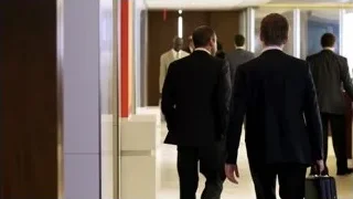 men in suits walking in office hallway — Suits