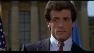 Man in suit speaking with American flag — Rocky III