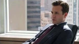 man in suit sitting by city window — Suits