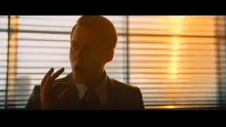 man in suit standing by window at sunset — John Wick: Chapter 4