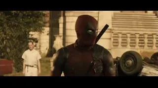 Deadpool holding gun in front of building — Deadpool 2