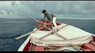 Man on boat in ocean holding oars — Life of Pi