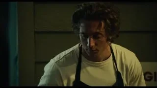 man in apron by 'The Original Beef' sign — The Bear