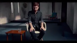 man sitting in dimly lit concrete room — The Social Dilemma