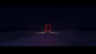 Red truck driving on empty road at night — Cars