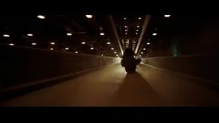 Person riding motorcycle on long bridge at night — Batman: The Dark Knight