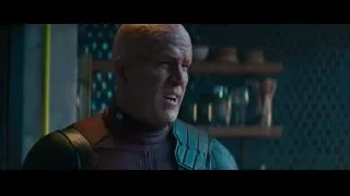 Bald man in red suit in dimly lit room — Deadpool 2