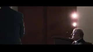man speaking into microphone at podium — The Big Short