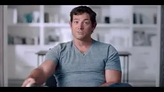 man sitting in living room with bookshelf — The Social Dilemma