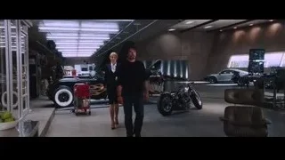 two men standing next to car in garage — Iron Man