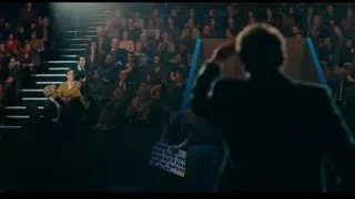 Man on stage with microphone to crowd — Joker
