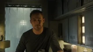 man sitting at dimly lit kitchen counter — Blade Runner 2049