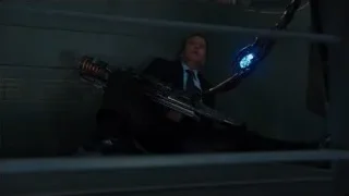 Man in suit sitting on bench with gun — The Avengers