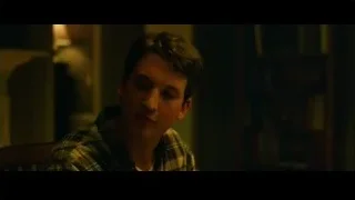 young man in plaid shirt in dimly lit room — Whiplash