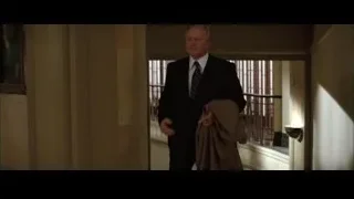 Man in suit walking down hallway — Batman