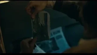 Person holding old newspaper with photo — Joker