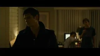 man in dimly lit room with others — The Social Network