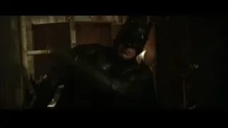person sitting in dimly lit cluttered room — Batman