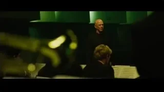 bald man giving speech at podium — Whiplash