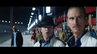 two men conversing on street at night — Ford v Ferrari