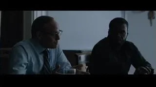 two men sitting at table in dimly lit room — Southpaw