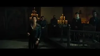 People in medieval clothing in dimly lit church — John Wick: Chapter 4